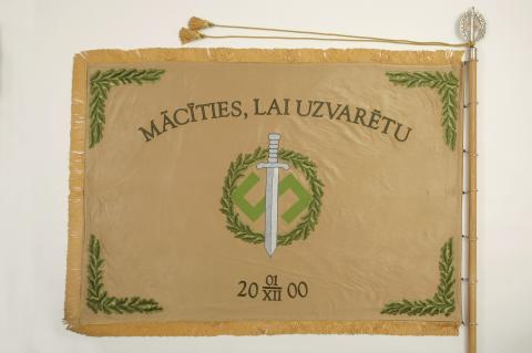 Sadaļa “Simbolika”, kuras bildē redzma Mācību vadības pavēlniecības karoga kreisā puse (averss).