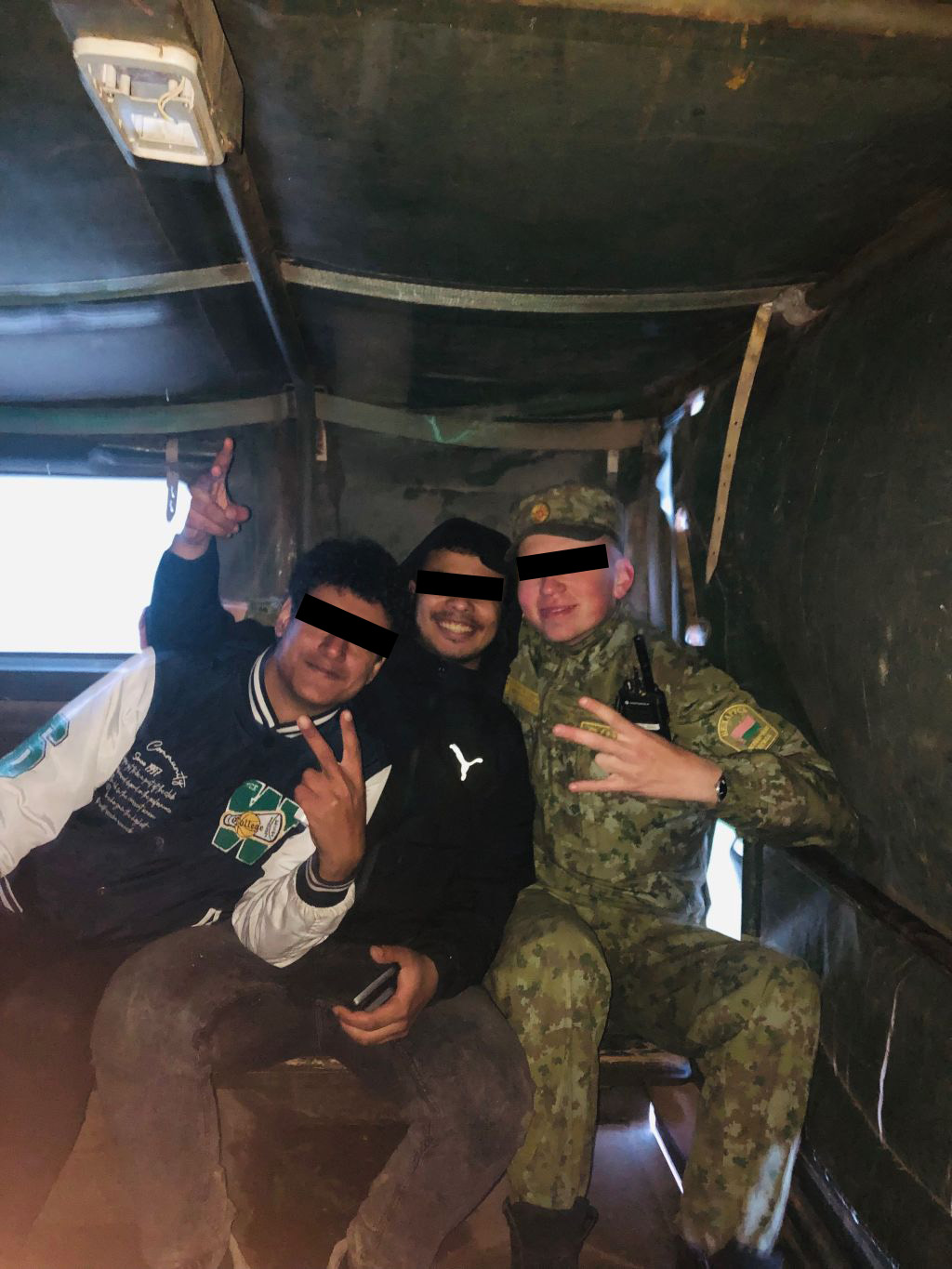 A Belarusian border guard escorting illegal migrants