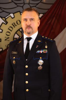 NP komandieris pulkvedis Jevgeņijs Kazenko uz Latvijas karoga fona
